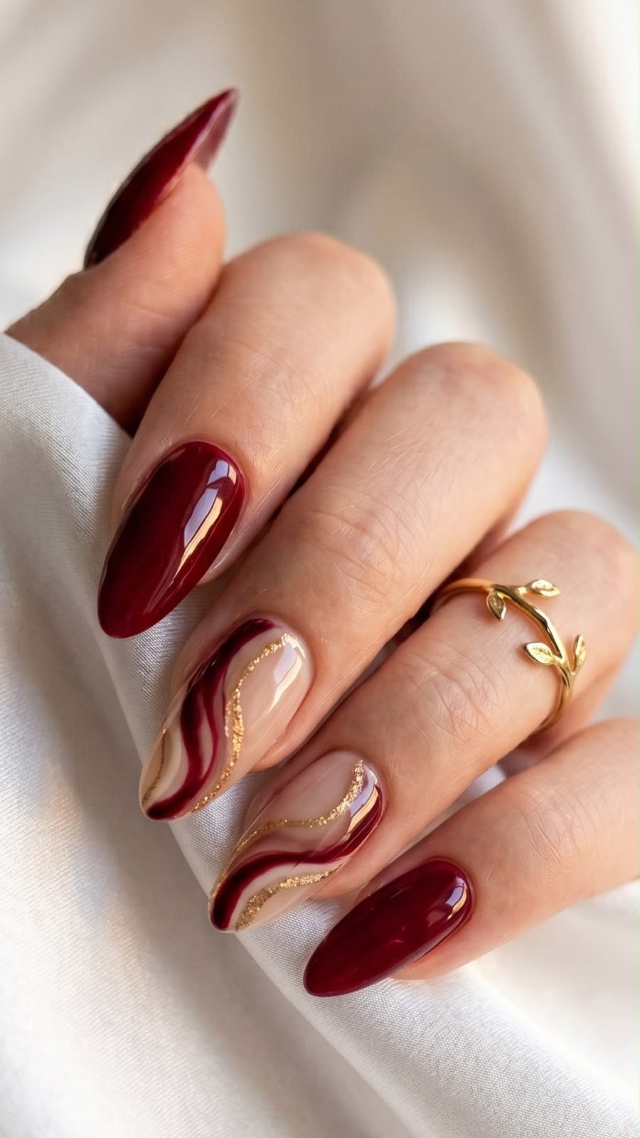 Unhas vinho com swirls dourados