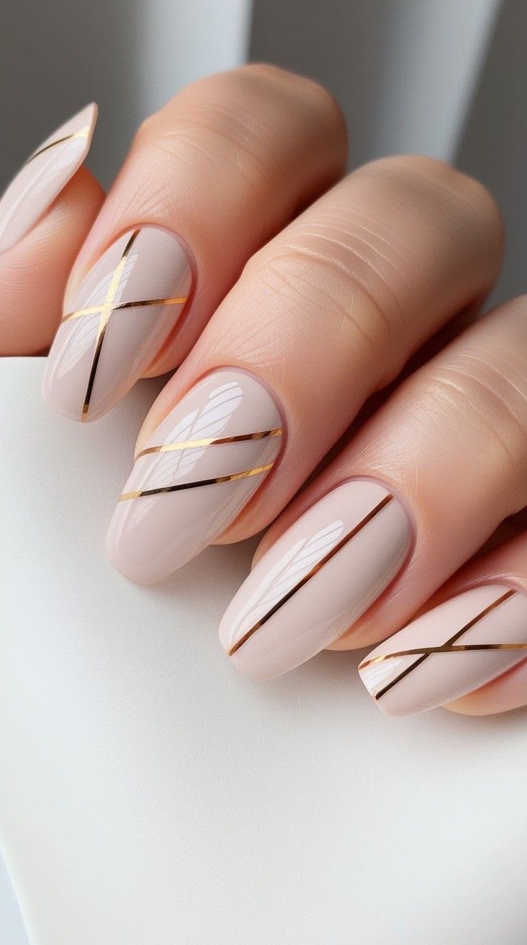 Unhas nude com linhas geométricas douradas